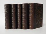 three old books sitting on top of each other on a white surface