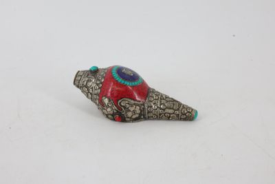 un gros plan d'une perle rouge et bleue sur une surface blanche