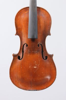 an old violin sitting on top of a white surface