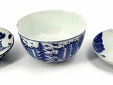 three blue and white bowls and a bowl on a white surface