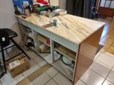 a kitchen island with a marble top in the middle of a room