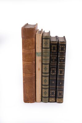 plusieurs vieux livres sont empilés sur une surface blanche
