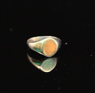 un gros plan d'une bague en argent sertie d'une pierre jaune