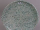 a green plate with a number on it on a white surface