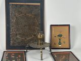 three framed pictures on a table with a vase and a lamp