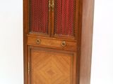 une vieille armoire en bois surmontée d'un rideau rouge