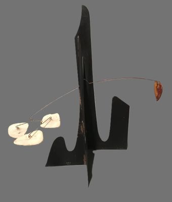 une sculpture en métal noir à l'extrémité de laquelle est suspendue une feuille