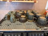 de nombreuses tasses et mugs posés sur un support dans la cuisine