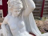 a statue of a woman sitting on the ground