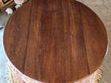 a round table with a wooden top on a rug