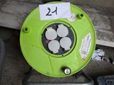 un souffleur vert posé par terre à côté d'une boîte à outils