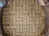 a wooden chair that has a woven seat on top of it