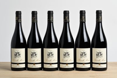 six bottles of wine are lined up on a wooden table