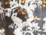 a large black and white screen with birds and flowers