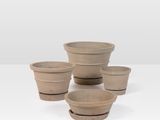 quatre petits pots en argile empilés les uns sur les autres sur une table