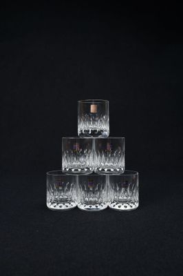 quatre verres de whisky empilés les uns sur les autres sur un fond noir