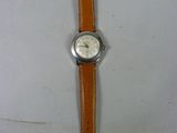 une image d'une montre sur une surface blanche avec un bracelet marron