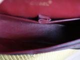 a close up of a person ' s hand holding a red purse