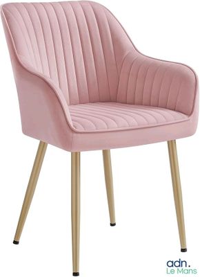 Le fauteuil en velours rose est recouvert de tissu et possède des pieds dorés.