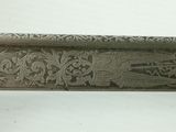 an old silver plate with a design on it sitting on a table