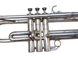 a silver trumpet that is sitting on a white surface