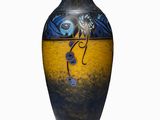 a blue and yellow vase sitting on a white surface