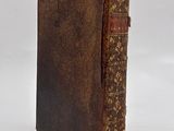 an old book sitting on top of a white surface