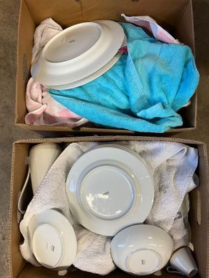 a box with two cups and a plate in it