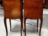 two wooden chairs sitting next to each other on a tiled floor
