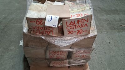 une pile de cartons posée sur une palette, sur laquelle est accrochée une pancarte