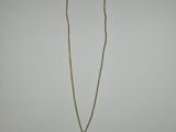 un collier en or avec un pendentif circulaire au bout d'une chaîne