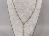 un collier avec une croix autour du cou d'un mannequin