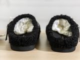 a pair of black slippers that are sitting on a table