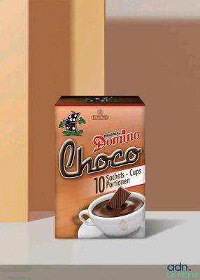 une boîte de café posée sur une table, à côté d'une tasse de café