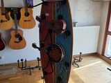 a surfboard on a stand in a room with guitars on the wall