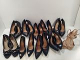 several pairs of black shoes are lined up on a white surface