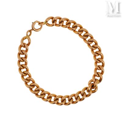 gros plan d'un bracelet en chaîne en or sur fond blanc