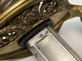 a close up of a sword on a white surface