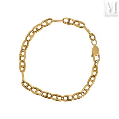 gros plan d'un bracelet en chaîne en or sur fond blanc