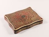an old box with a decorative design on it on a white surface