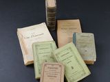 several old books sitting on top of a table next to a stack of books