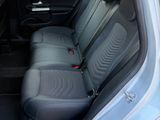 the back seats of a silver car are empty in a parking lot
