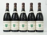 six bouteilles de vin sont alignées sur une table
