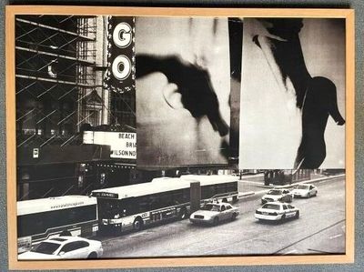 black and white photograph of a city street with cars, buses, and a giant billboard