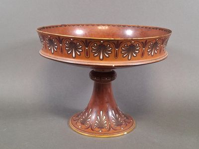 a brown cake stand with a decorative design on it