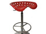 Le tabouret rouge est doté d'un piètement métallique et d'un repose-pieds métallique.
