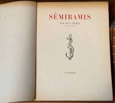 un livre ouvert posé sur une étagère en bois, à côté d'une pile de livres