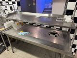 a stainless steel counter with a sink in the middle of it
