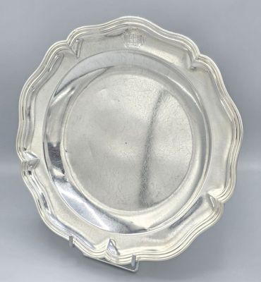 a silver plate with a scalloped edge on a gray background