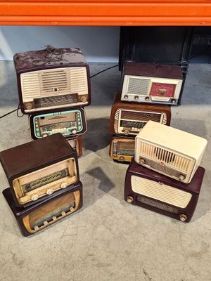 several old radio ' s are stacked on top of each other on the floor
